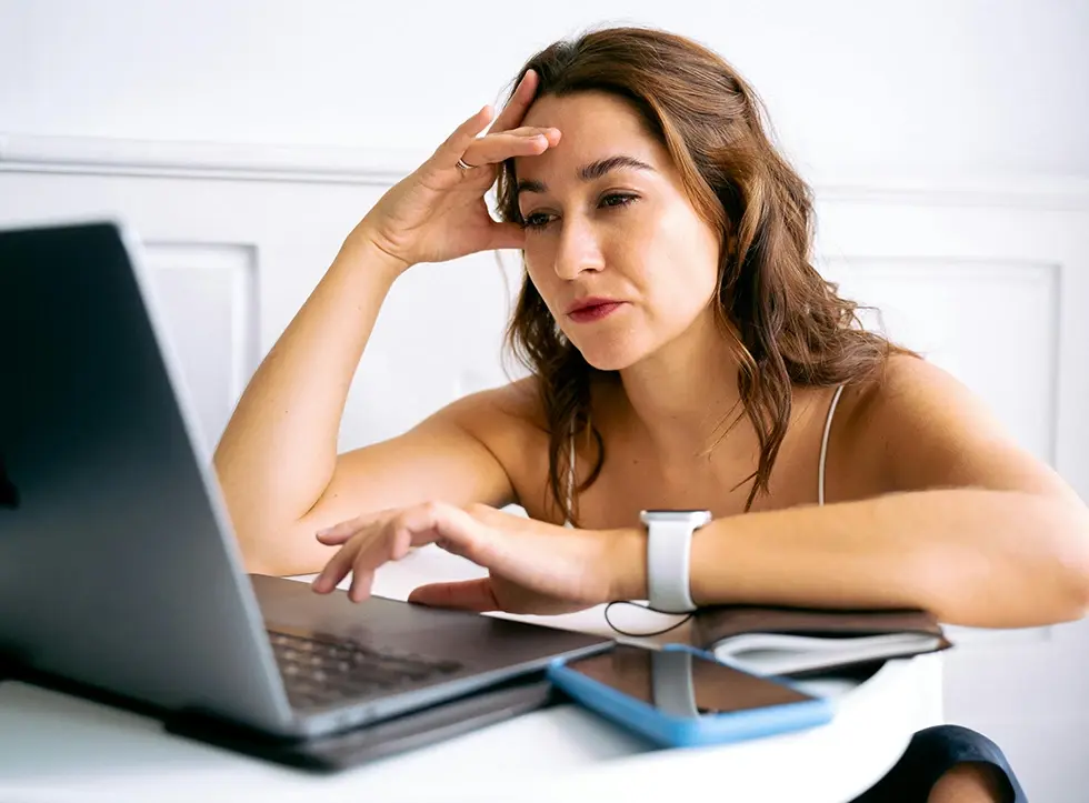 Woman looking annoyed at her laptop screen