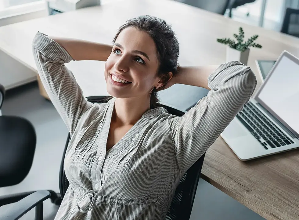Woman leaning back in her office chair, relaxed